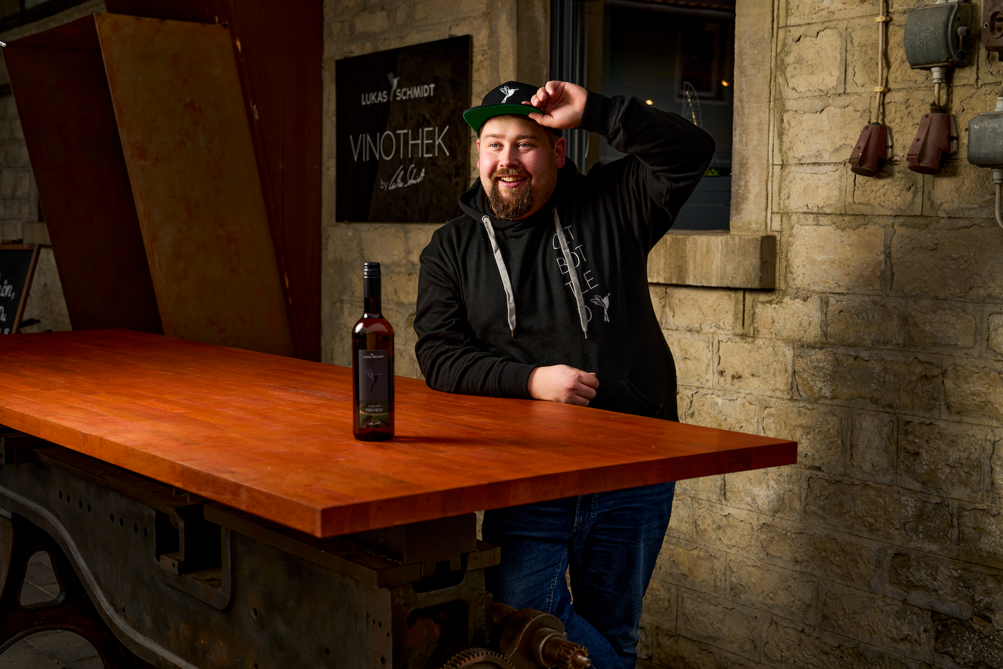 Jungwinzer Lukas Schmidt mit einer Flasche Wein Sneak Preview