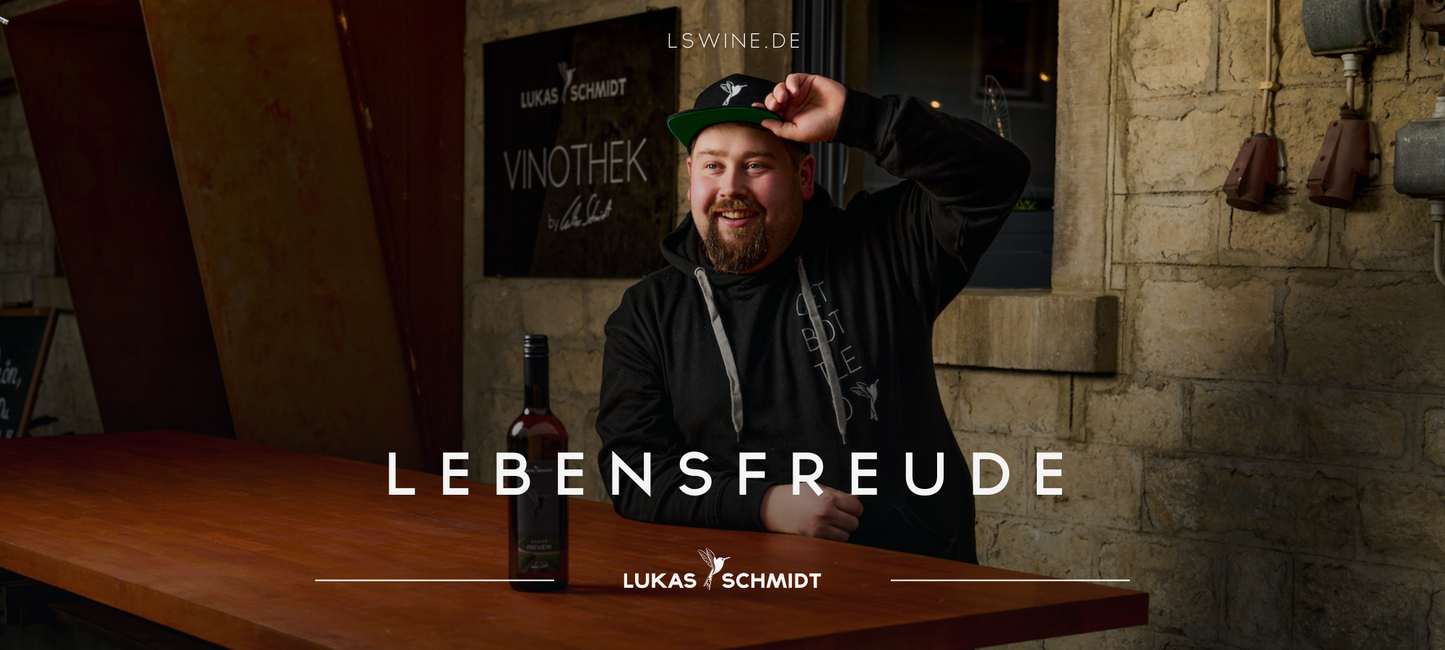 LUKAS SCHMIDT Jungwinzer vor seiner Vinothek mit einer Flasche Sneak Preview